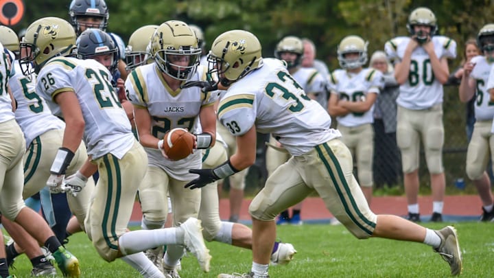 Windsor's Brooks Ruderman hands the ball to Gavin Martin for a short gain during the Yellowjackets 32-12 win over the Mount Mansfield Cougars on Saturday afternoon in Jericho.