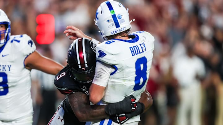 Sep 27, 2025; Columbia, South Carolina, USA; South Carolina Gamecocks linebacker Desmond Umeozulu (9) hits Kentucky Wildcats quarterback Cutter Boley (8) as he passes which causes an interception in the second quarter at Williams-Brice Stadium. Mandatory Credit: Jeff Blake-Imagn Images