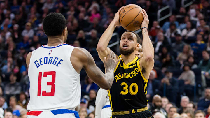 Feb 14, 2024; San Francisco, California, USA; Golden State Warriors guard Stephen Curry (30) passes over LA Clippers forward Paul George (13) during the first half at Chase Center. Mandatory Credit: John Hefti-Imagn Images