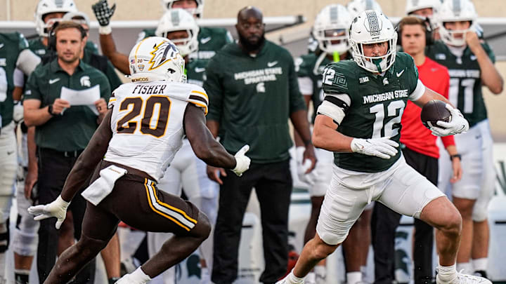 Michigan State tight end Jack Velling (12) makes a catch against Western Michigan defensive end Kershawn Fisher (20) during the first half at Spartan Stadium in East Lansing on Friday, August 29, 2025.
