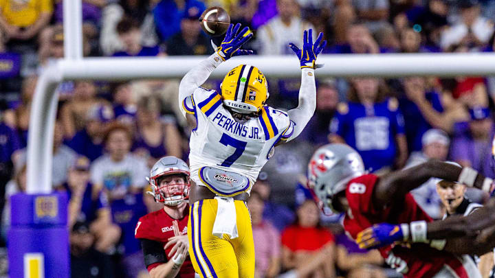 Sep 7, 2024; Baton Rouge, Louisiana, USA; Nicholls State Colonels quarterback Pat McQuaide (7) rolls out of the pocket against LSU Tigers linebacker Harold Perkins Jr. (7) during the second half at Tiger Stadium. Mandatory Credit: Stephen Lew-Imagn Images Sep 7, 2024; Baton Rouge, Louisiana, USA; Nicholls State Colonels quarterback Pat McQuaide (7) rolls out of the pocket against LSU Tigers linebacker Harold Perkins Jr. (7) during the second half at Tiger Stadium. Mandatory Credit: Stephen Lew-Imagn Images
