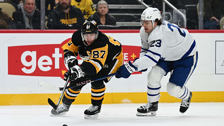 Sidney Crosby battles for the puck with Matthew Knies