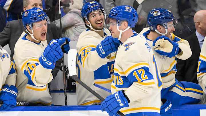 Feb 8, 2025; St. Louis, Missouri, USA;  St. Louis Blues center Radek Faksa (12) is congratulated by center Zack Bolduc (76) and center Jordan Kyrou (25) after scoring the game winning goal in the 10th round of shootouts against the Chicago Blackhawks at Enterprise Center. Mandatory Credit: Jeff Curry-Imagn Images