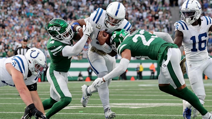 Nov 17, 2024; East Rutherford, New Jersey, USA; Indianapolis Colts quarterback Anthony Richardson (5) runs with the ball for a touchdown against New York Jets cornerbacks D.J. Reed (4) and Isaiah Oliver (23) during the fourth quarter at MetLife Stadium. Mandatory Credit: Brad Penner-Imagn Images