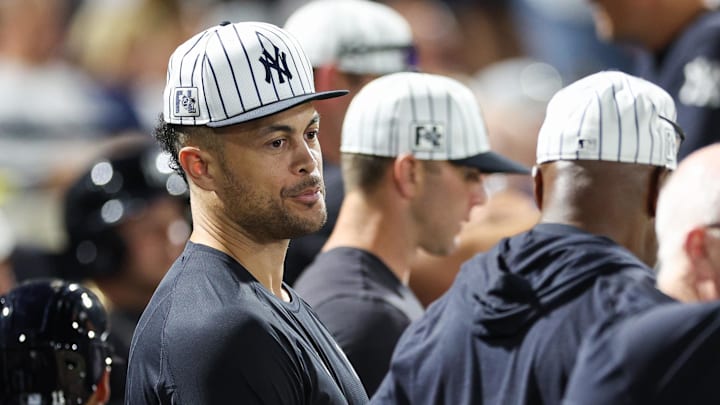 Mar 14, 2025; Tampa, Florida, USA; New York Yankees designated hitter Giancarlo Stanton (27) looks on from the dugout against the Philadelphia Phillies.