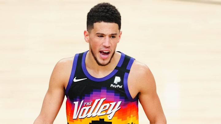 Jul 8, 2021; Phoenix, Arizona, USA; Phoenix Suns guard Devin Booker (1) reacts in front of Milwaukee Bucks guard Jrue Holiday (21) during the first half in game two of the 2021 NBA Finals at Phoenix Suns Arena. Mandatory Credit: Mark J. Rebilas-Imagn Images