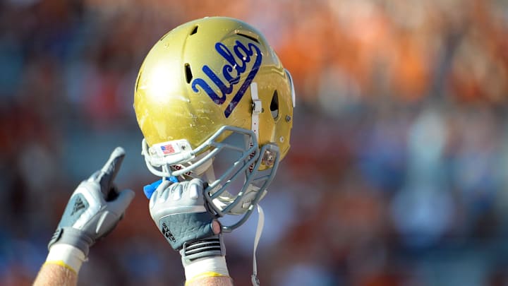 Sept 25, 2010; Austin, TX, USA; A member of the UCLA Bruins holds up his helmet to acknowledge their fans against the Texas Longhorns during the fourth quarter at Texas Memorial Stadium. UCLA beat Texas 34-12. Mandatory Credit: Brendan Maloney-Imagn Images Sept 25, 2010; Austin, TX, USA; A member of the UCLA Bruins holds up his helmet to acknowledge their fans against the Texas Longhorns during the fourth quarter at Texas Memorial Stadium. UCLA beat Texas 34-12. Mandatory Credit: Brendan Maloney-Imagn Images