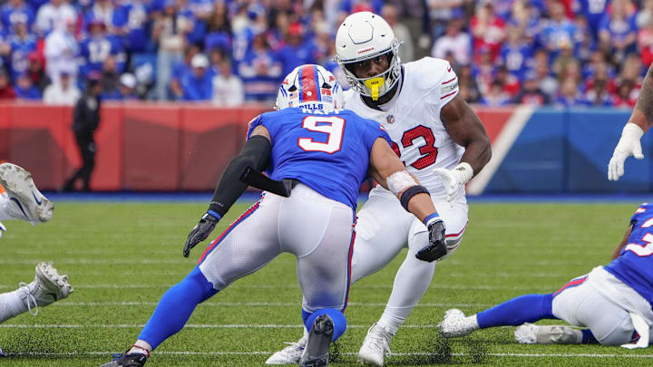 Sep 8, 2024; Orchard Park, New York, USA; Arizona Cardinals running back Trey Benson (33) runs with the ball against Buffalo Bills safety Taylor Rapp (9) during the first half at Highmark Stadium. 