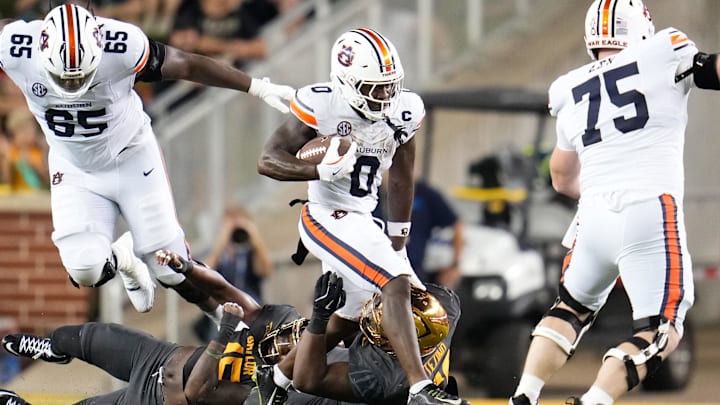 Aug 29, 2025; Waco, Texas, USA;  Auburn Tigers running back Damari Alston (0) runs the ball against Baylor Bears defensive lineman Devonte Tezino (59) during the first half at McLane Stadium. Mandatory Credit: Chris Jones-Imagn Images