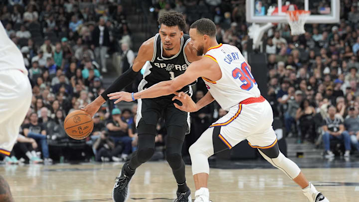 San Antonio Spurs center Victor Wembanyama (1) dribbles against Golden State Warriors guard Stephen Curry (30) in the first half at Frost Bank Center. Mandatory Credit: Daniel Dunn-Imagn Images