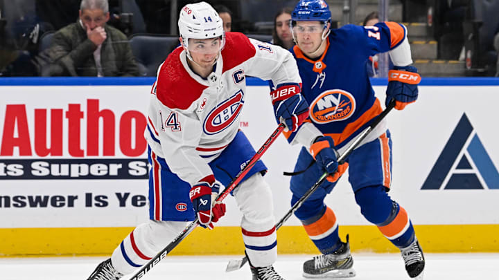 Apr 11, 2024; Elmont, New York, USA; Montreal Canadiens center Nick Suzuki (14) attempts a pass against the New York Islanders during the first period at UBS Arena. Mandatory Credit: Dennis Schneidler-USA TODAY Sports