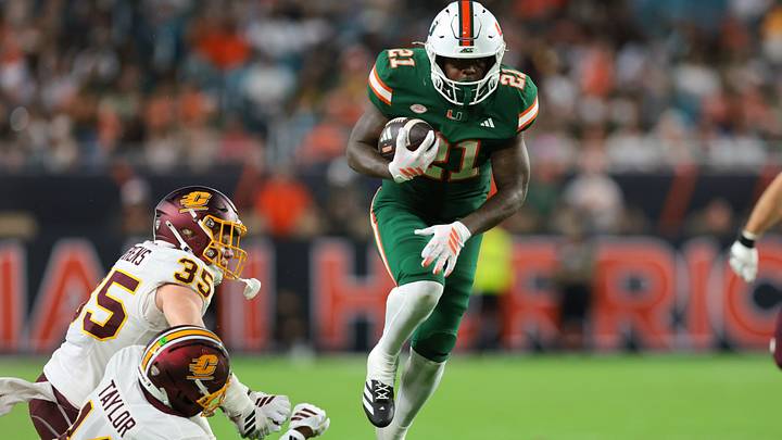 Sep 26, 2026; Miami Gardens, Florida, USA; Miami Hurricanes running back Javian Mallory (21) breaks a tackle against Central Michigan Chippewas linebacker Mayson Hitchens (35) and defensive back Justin Taylor (14) during the second quarter at Hard Rock Stadium. Mandatory Credit: Sam Navarro-Imagn Images Sep 26, 2026; Miami Gardens, Florida, USA; Miami Hurricanes running back Javian Mallory (21) breaks a tackle against Central Michigan Chippewas linebacker Mayson Hitchens (35) and defensive back Justin Taylor (14) during the second quarter at Hard Rock Stadium. Mandatory Credit: Sam Navarro-Imagn Images