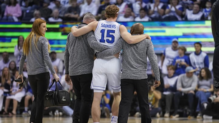 Feb 14, 2026; Provo, Utah, USA; BYU Cougars guard Richie Saunders (15) is helped off the court after an injury during the first half against the Colorado Buffaloes at the Marriott Center. Mandatory Credit: Aaron Baker-Imagn Images
