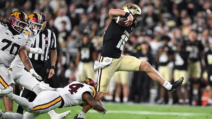 Purdue Boilermakers quarterback Ryan Browne (15) jumps to evade tackle.