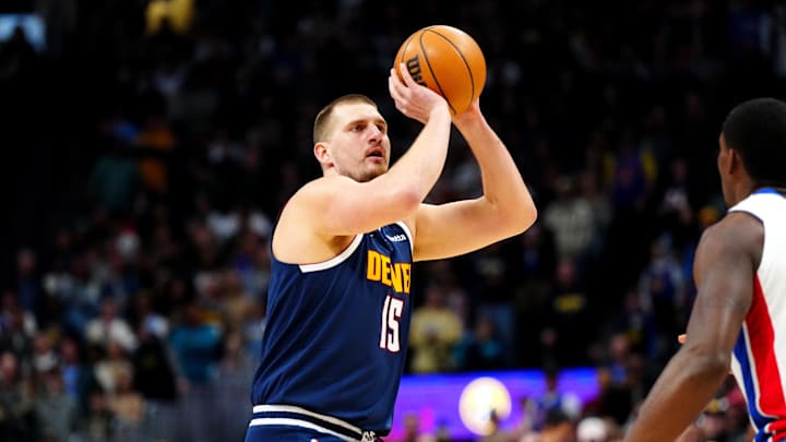 Dec 28, 2024; Denver, Colorado, USA; Denver Nuggets center Nikola Jokic (15) lines up a three point shot in the first quarter against the Detroit Pistons at Ball Arena. Mandatory Credit: Ron Chenoy-Imagn Images