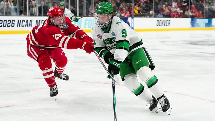 Apr 9, 2026; Las Vegas, Nevada, UNITED STATES; North Dakota Fighting Hawks forward Will Zellers (9) moves the puck while defended by Wisconsin Badgers defenseman Weston Knox (26) in the third period in the semifinals of the NCAA men's ice hockey Frozen Four at T-Mobile Arena. Mandatory Credit: Stephen R. Sylvanie-Imagn Images