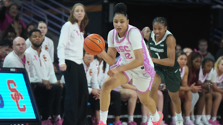 Feb 19, 2025; Los Angeles, California, USA; Southern California Trojans guard JuJu Watkins (12) dribbles the ball against Michigan State Spartans guard Jaddan Simmons (1) in the first half at Galen Center. Mandatory Credit: Kirby Lee-Imagn Images