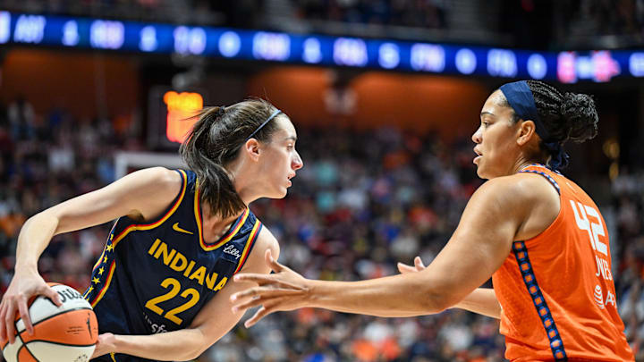 Sep 22, 2024; Uncasville, Connecticut, USA; Indiana Fever guard Caitlin Clark (22) looks to pass the ball defended by Connecticut Sun forward Brionna Jones (42) in the first quarter during game one of the first round of the 2024 WNBA Playoffs at Mohegan Sun Arena. Mandatory Credit: Mark Smith-Imagn Images