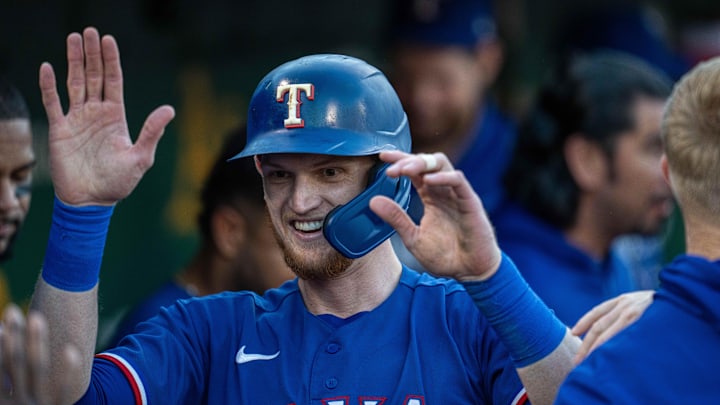 Aug 8, 2023; Oakland, California, USA;  Texas Rangers catcher Sam Huff (55) gets high fives from teammates in the dugout after scoring against the Oakland Athletics during the fourth inning at Oakland-Alameda County Coliseum. Mandatory Credit: Neville E. Guard-Imagn Images