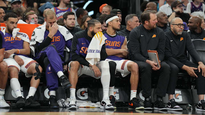 Apr 11, 2025; Phoenix, Arizona, USA; Phoenix Suns guard Devin Booker (1) sits amongst coaches and teammates during the second half against the San Antonio Spurs at Footprint Center. Mandatory Credit: Joe Camporeale-Imagn Images