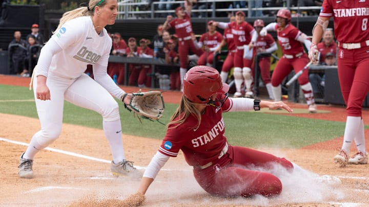 Stanford’s River Mahler, center, slides home in the first inning after a wild pitch by Oregon’s Lyndsey Grein.