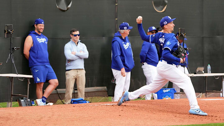 Feb 12, 2025; Glendale, AZ, USA; Los Angeles Dodgers pitcher Blake Snell (7) throws as pitcher Clayton Kershaw (left) looks on during a Spring Training workout at Camelback Ranch. Mandatory Credit: Joe Camporeale-Imagn Images