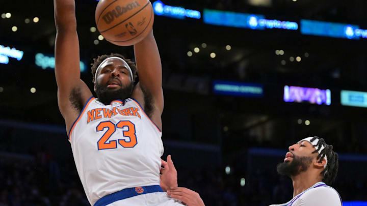 Feb 5, 2022; Los Angeles, California, USA;   New York Knicks center Mitchell Robinson (23) hangs on the rim after a dunk as Los Angeles Lakers forward Anthony Davis (3) looks on in the first quarter of the game at Crypto.com Arena. Mandatory Credit: Jayne Kamin-Oncea-Imagn Images