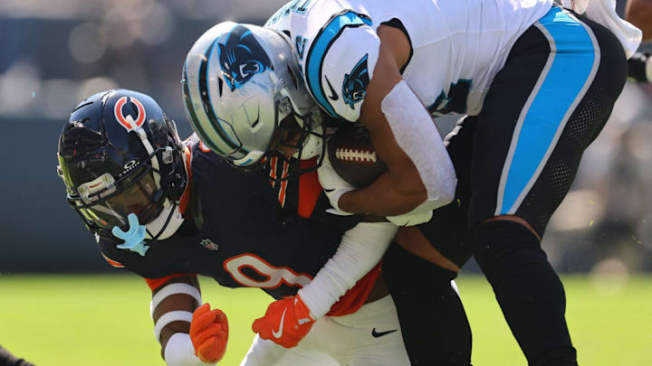 CHICAGO, ILLINOIS - OCTOBER 06: Jaquan Brisker #9 of the Chicago Bears forces a fumble by Tommy Tremble #82 of the Carolina Panthers during the second quarter at Soldier Field on October 06, 2024 in Chicago, Illinois. 