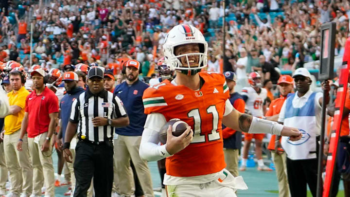 Nov 8, 2025; Miami Gardens, Florida, USA; Miami Hurricanes quarterback Carson Beck (11) catches a touchdown pass against the Syracuse Orange during the second quarter at Hard Rock Stadium. Mandatory Credit: Jeff Romance-Imagn Images