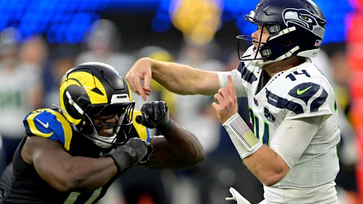Nov 16, 2025; Inglewood, California, USA; Seattle Seahawks quarterback Sam Darnold (14) is pressured by Los Angeles Rams linebacker Byron Young (0) at SoFi Stadium. 