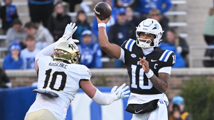 Nov 29, 2025; Durham, North Carolina, USA;  Duke Blue Devils quarter back Darian Mensah (10) throws the ball under pressure from Wake Forest Demon Deacons defensive lineman Gabe Kirschke (10) during the first quarter at Wallace Wade Stadium. Mandatory Credit: Zachary Taft-Imagn Images
