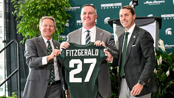 Michigan State football's new coach Pat Fitzgerald, center, holds up a jersey with MSU President Kevin Guskiewicz, left, and athletic director J Batt, right, during Fitzgerald's introductory press conference on Tuesday, Dec. 2, 2025, at the Tom Izzo Football Building in East Lansing. Michigan State football's new coach Pat Fitzgerald, center, holds up a jersey with MSU President Kevin Guskiewicz, left, and athletic director J Batt, right, during Fitzgerald's introductory press conference on Tuesday, Dec. 2, 2025, at the Tom Izzo Football Building in East Lansing.
