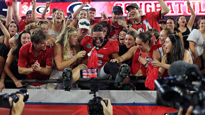Georgia Bulldogs quarterback Carson Beck (15) jumps into the student section after the game of an NCAA college football matchup Saturday, Nov. 2, 2024 at EverBank Stadium in Jacksonville, Fla. The Georgia Bulldogs defeated the Florida Gators 34-20.