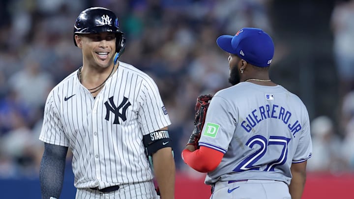 Aug 2, 2024; Bronx, New York, USA; New York Yankees designated hitter Giancarlo Stanton (27) talks to Toronto Blue Jays first baseman Vladimir Guerrero Jr. (27) at second base after hitting a double during the seventh inning at Yankee Stadium. Mandatory Credit: Brad Penner-Imagn Images