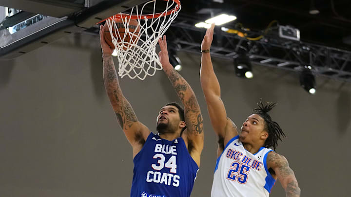 Dec 22, 2021; Las Vegas, NV, USA; Delaware Blue Coats guard Jarron Cumberland (34) shoots inside the defense of Oklahoma City Blue guard Rob Edwards (25) during the fourth quarter at Mandalay Bay Convention Center. Mandatory Credit: Stephen R. Sylvanie-Imagn Images