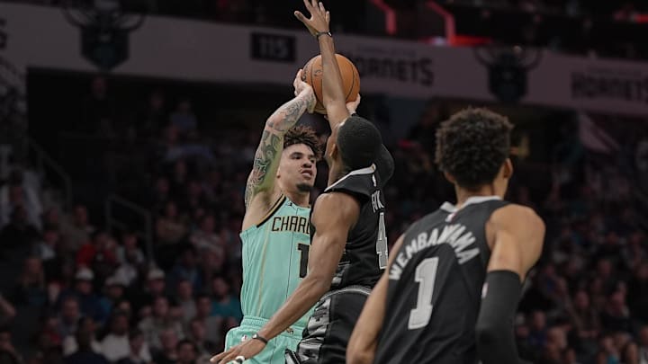 Feb 7, 2025; Charlotte, North Carolina, USA; Charlotte Hornets guard LaMelo Ball (1) looks to pass against San Antonio Spurs guard De'Aaron Fox (4) during the first quarter at Spectrum Center. Mandatory Credit: Jim Dedmon-Imagn Images