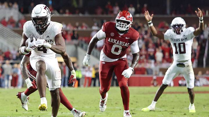Texas A&M Aggies running back Rueben Owens II (4) rushes for a touchdown during the fourth quarter as quarterback Marcel Reed (10) and Arkansas Razorbacks defensive lineman Justus Boone (0) look on at Donald W. Reynolds Razorback Stadium. 