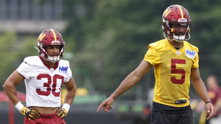Jun 5, 2024; Ashburn, VA, USA; Washington Commanders quarterback Jayden Daniels (5) gestures as Commanders running back Austin Ekeler (30) looks on during OTA workouts at Commanders Park. Mandatory Credit: Geoff Burke-USA TODAY Sports Jun 5, 2024; Ashburn, VA, USA; Washington Commanders quarterback Jayden Daniels (5) gestures as Commanders running back Austin Ekeler (30) looks on during OTA workouts at Commanders Park. Mandatory Credit: Geoff Burke-USA TODAY Sports