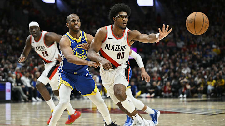 Apr 11, 2024; Portland, Oregon, USA; Portland Trail Blazers guard Scoot Henderson (00) passes the ball while being defended by Golden State Warriors guard Chris Paul.