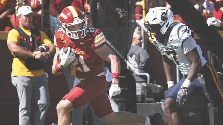 Iowa State running back Aiden Flora (21) runs with the ball for a touchdown as West Virginia defensive back Chams Diagnu (7) pursues during the third quarter of a Big 12 Conference football game on Oct. 3, 2026, at Jack Trice Stadium in Ames, Iowa. Iowa State running back Aiden Flora (21) runs with the ball for a touchdown as West Virginia defensive back Chams Diagnu (7) pursues during the third quarter of a Big 12 Conference football game on Oct. 3, 2026, at Jack Trice Stadium in Ames, Iowa.