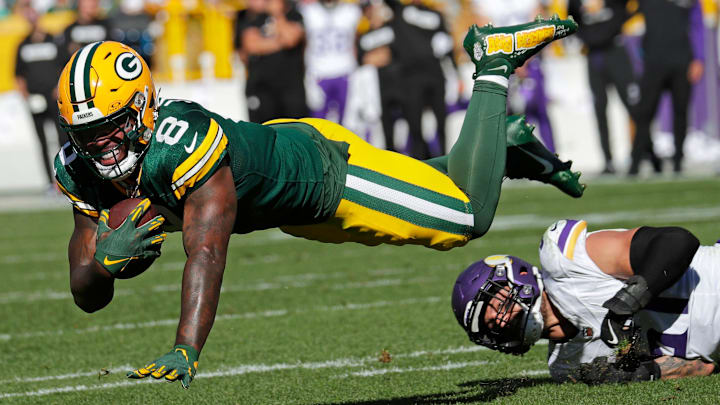 Green Bay Packers running back Josh Jacobs (8) dives for yardage against Minnesota Vikings linebacker Blake Cashman.