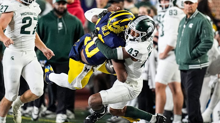 Michigan quarterback Alex Orji (10) is brought down by Michigan State defensive back Malik Spencer (43) during the second half at Michigan Stadium in Ann Arbor on Saturday, Oct. 26, 2024.