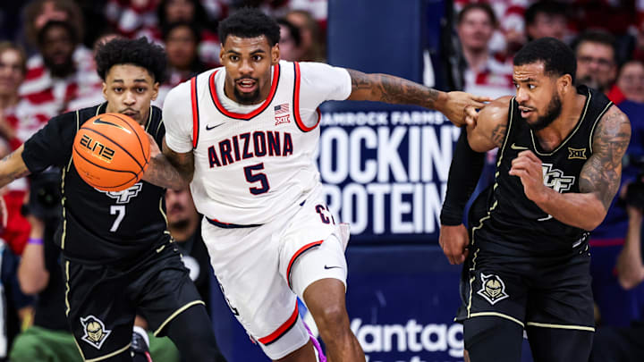 Arizona Wildcats guard KJ Lewis (5) runs with the ball against UCF Knights guards Dior Johnson (7) and Darius Johnson (3) during the second half of the game at McKale Center.