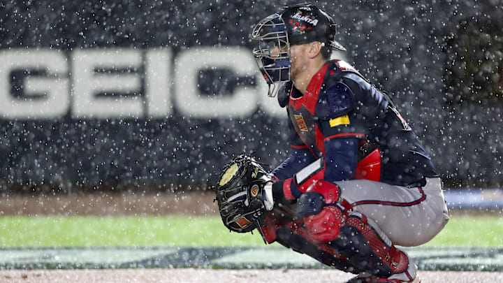 Atlanta Braves catcher Sean Murphy (12) prepares to defend the plate as rain falls during the first inning of the Speedway Classic game against the Cincinnati Reds at Bristol Motor Speedway.