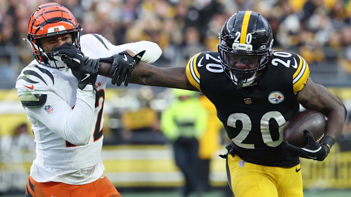 Nov 16, 2025; Pittsburgh, Pennsylvania, USA; Pittsburgh Steelers running back Kaleb Johnson (20) stiff arms Cincinnati Bengals safety Geno Stone (22) during the second half at Acrisure Stadium. Mandatory Credit: Charles LeClaire-Imagn Images