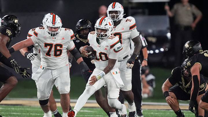 Sep 18, 2026; Winston-Salem, North Carolina, USA;  Miami (FL) Hurricanes quarterback Darian Mensah (10) is chased out of the pocket by the Wake Forest Demon Deacons during the first half at Allegacy Federal Credit Union Stadium.  Mandatory Credit: Jim Dedmon-Imagn Images