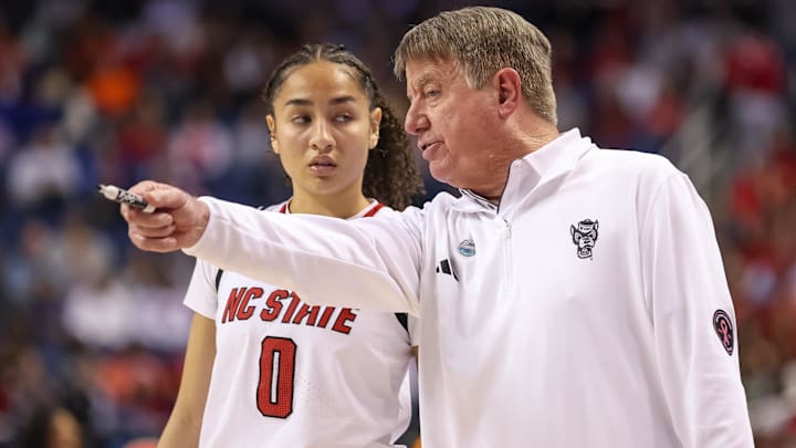 Mar 9, 2025; Greensboro, NC, USA;  NC State Wolfpack head coach Wes Moore talks with NC State Wolfpack guard Devyn Quigley (0) during the fourth quarter against Duke Blue Devils at First Horizon Coliseum. Mandatory Credit: Cory Knowlton-Imagn Images