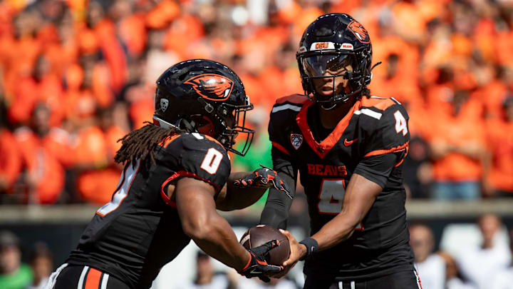 Oregon State quarterback Gevani McCoy hands the ball off to  running back Anthony Hankerson 