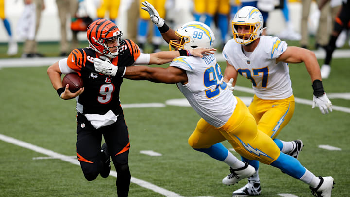 Sep 13, 2020; Cincinnati, OH, USA;  Cincinnati Bengals quarterback Joe Burrow (9) is pulled down by Los Angeles Chargers defensive tackle Jerry Tillery (99) in the first quarter of the NFL Week 1 game between the Cincinnati Bengals and the Los Angeles Chargers at Paul Brown Stadium in downtown Cincinnati on Sunday, Sept. 13, 2020.

Mandatory Credit: Sam Greene/Cincinnati Enquirer-USA TODAY NETWORK