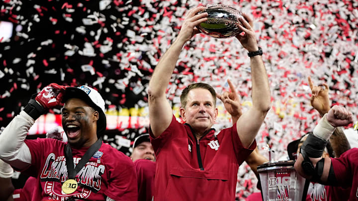 Indiana Hoosiers head coach Curt Cignetti hoists the trophy following their win over the Ohio State Buckeyes following the Big Ten Conference championship game at Lucas Oil Stadium in Indianapolis on Dec. 6, 2025. Ohio State lost 13-10.